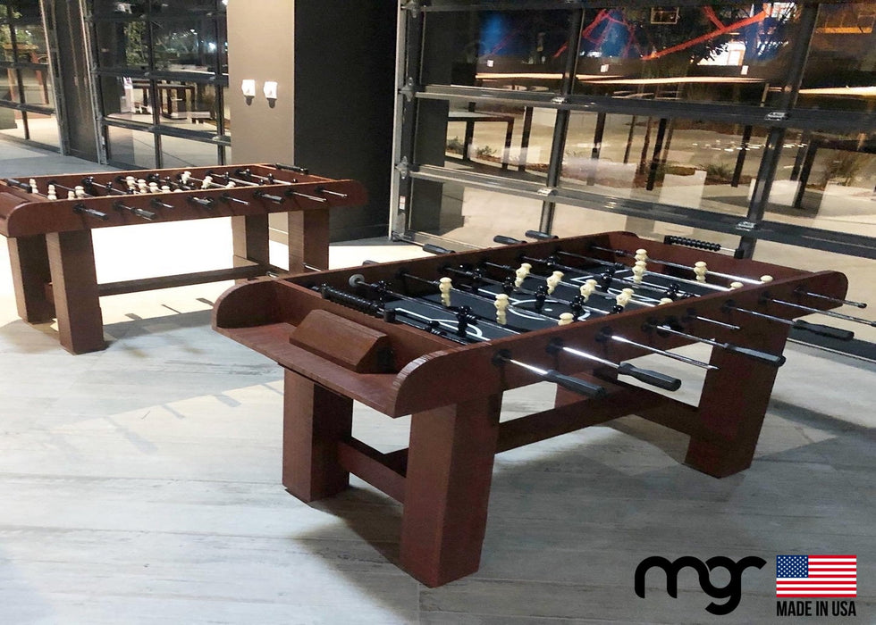 Foosball table with 'MGR' branding in a room setting