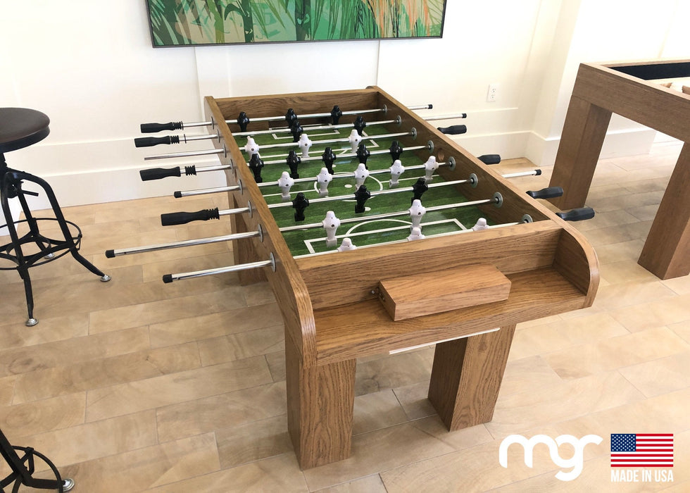 Wooden foosball table in a room with a painting on the wall