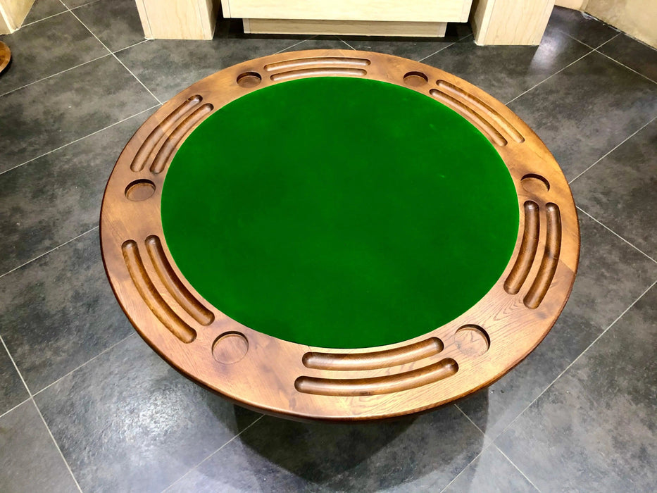Round green table with wooden border on a tiled floor