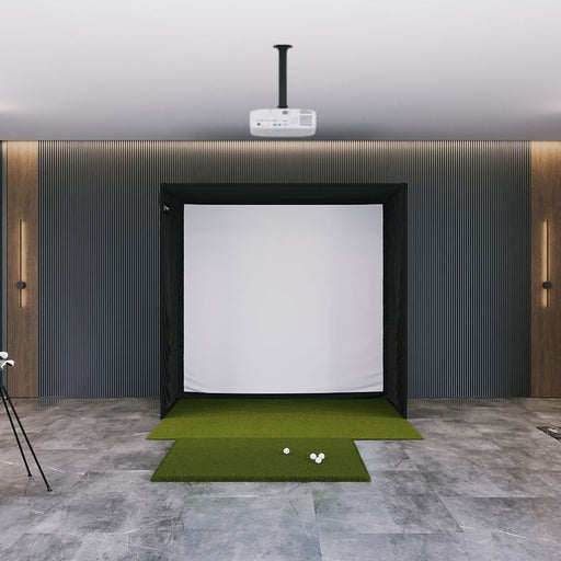Indoor golf simulator setup with screen and golf balls on a green mat.