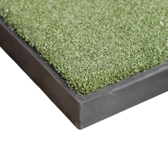 Close-up of a green artificial grass mat with a black border on a white background