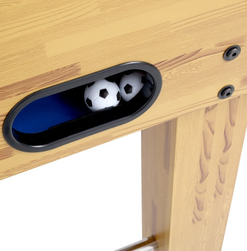 Two soccer balls inside a wooden table with a hole cut out.