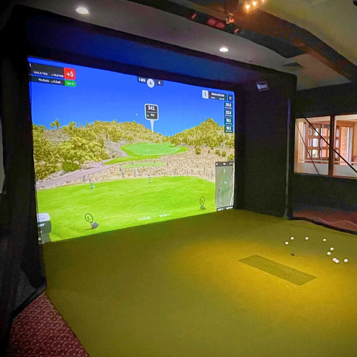 Indoor golf simulator setup with screen displaying a golf course.