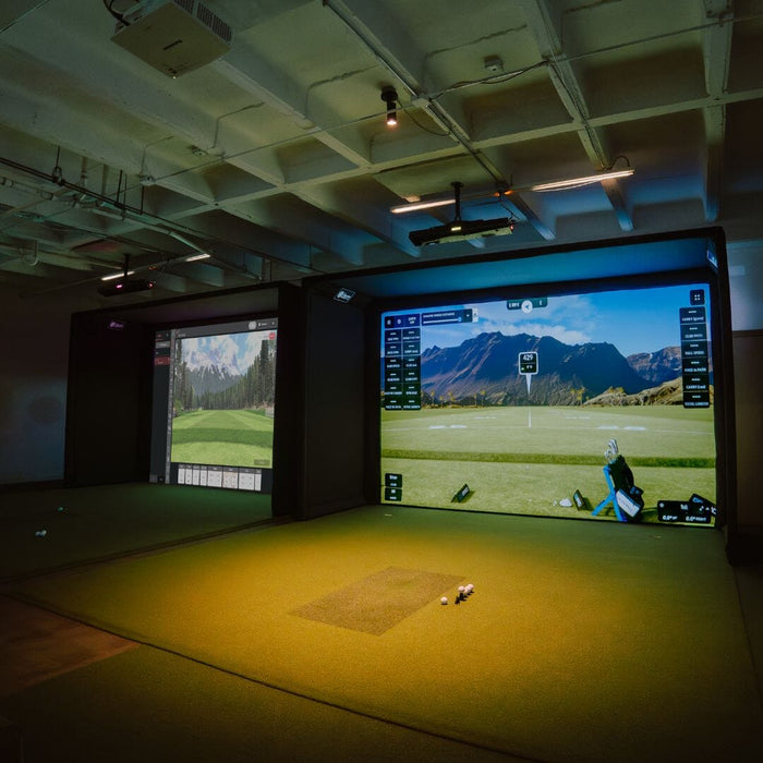 Golf simulator setup with two screens showing a golf course.