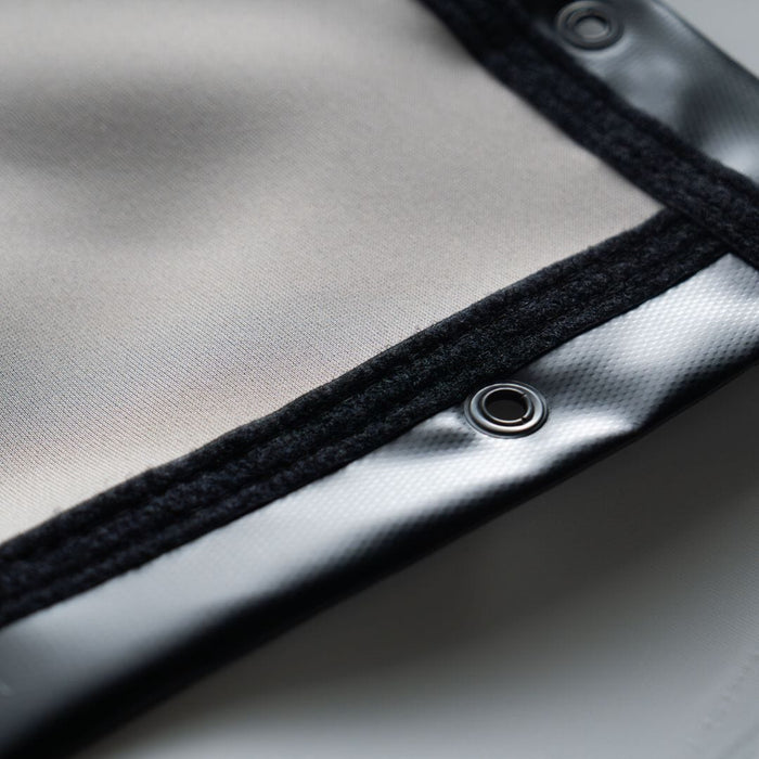 Close-up of a metallic surface with a black border and a button-like object.