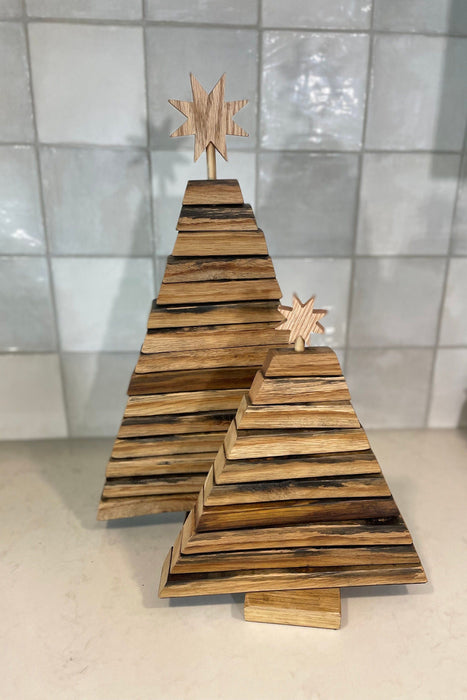 Wooden Christmas tree decoration with star topper on a tiled floor