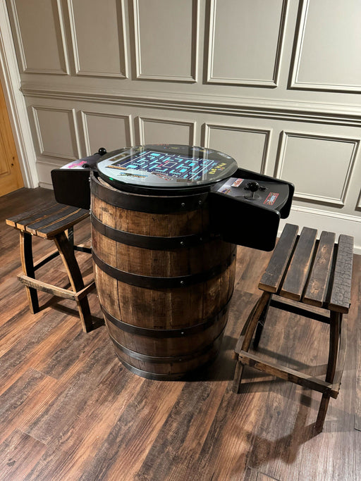 Barrel-shaped gaming console on a wooden floor with stools in a room.