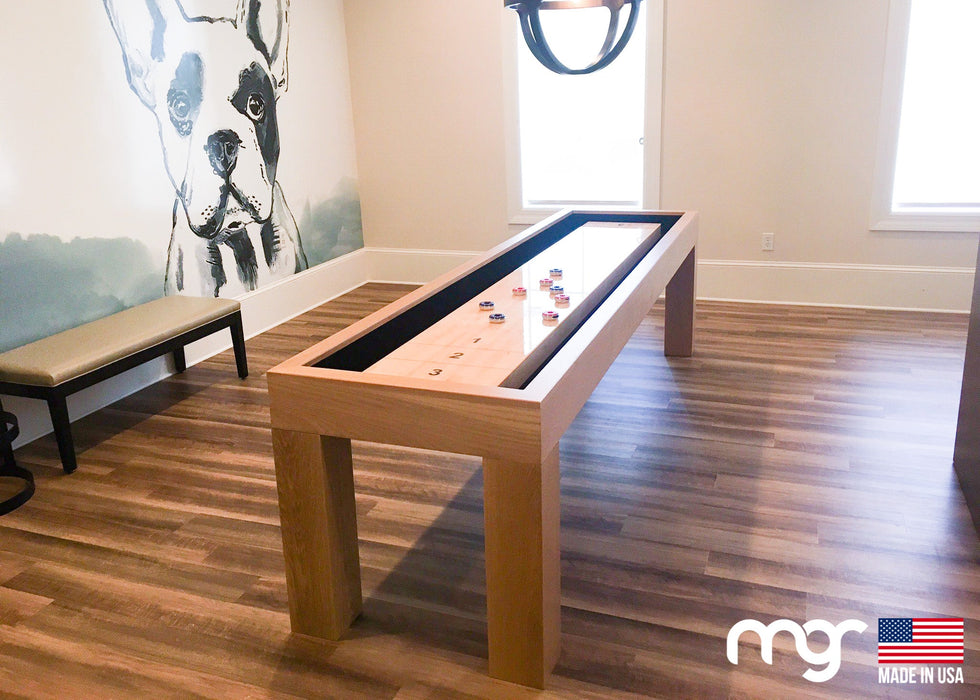 Wooden shuffleboard table in a room with a dog mural on the wall.