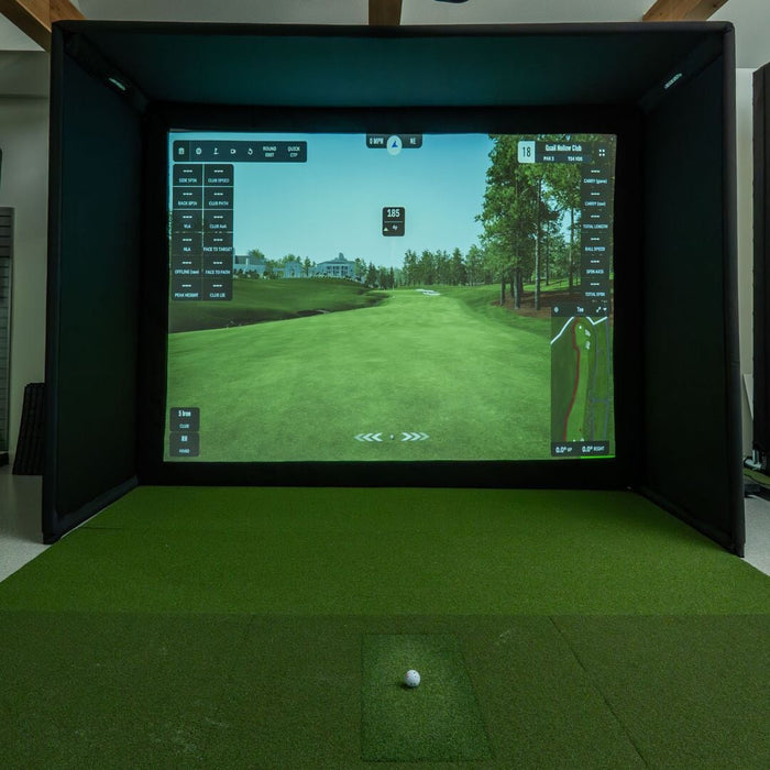 Golf simulator setup with screen displaying a golf course and a ball on the ground.