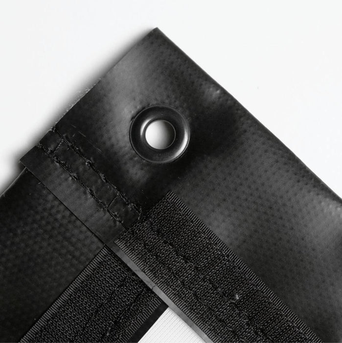 Close-up of a black fabric with a button and Velcro strip on a white background