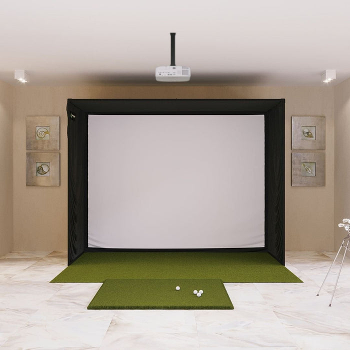 Indoor golf simulator setup with screen, projector, and golf balls on a green mat.