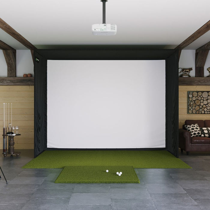 Indoor golf simulator setup with green mat and projector screen.