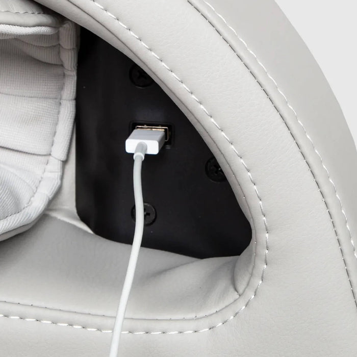 Close-up of a white leather bag with a USB charging port and cable.