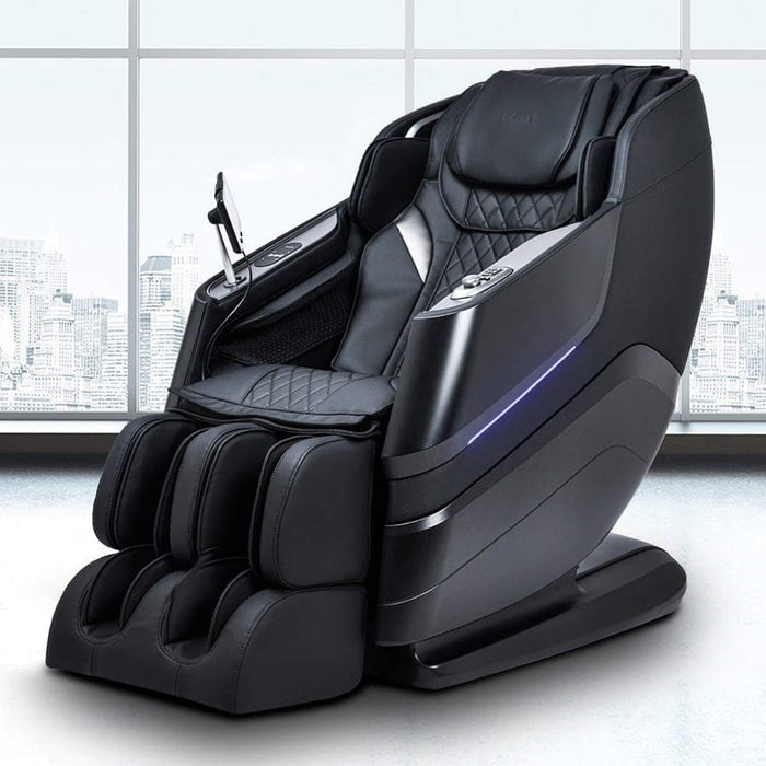 Black massage chair in a room with large windows showing a cityscape.
