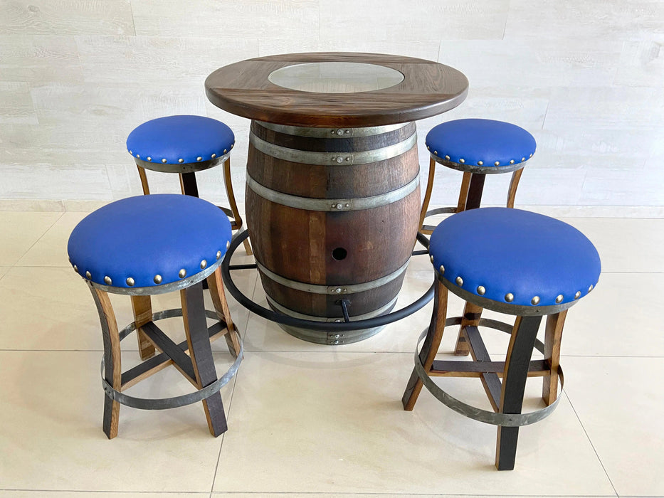 Wooden barrel table with four blue cushioned stools on a light wooden floor.