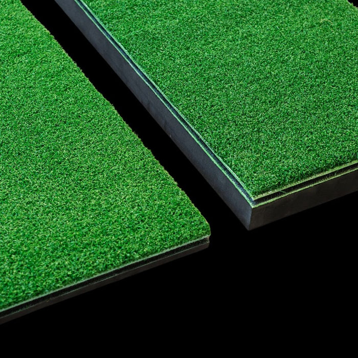 Two green artificial grass tiles on a black background