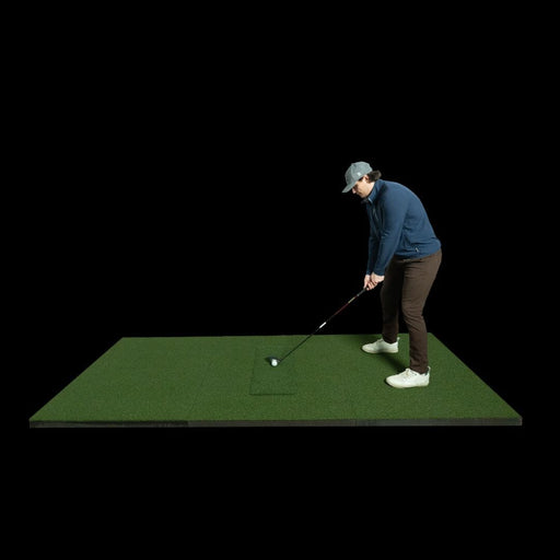 Person practicing golf on a green mat with a black background