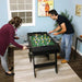 Two people playing foosball in a room with a window and decor.
