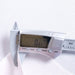 Digital caliper on a white fabric background