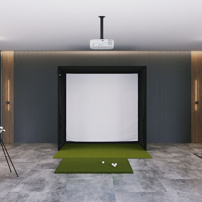 Indoor golf simulator setup with screen and golf balls on a green mat.