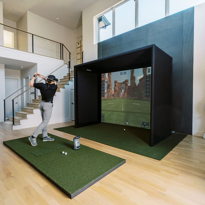 Person playing golf on a simulator in a modern indoor setting