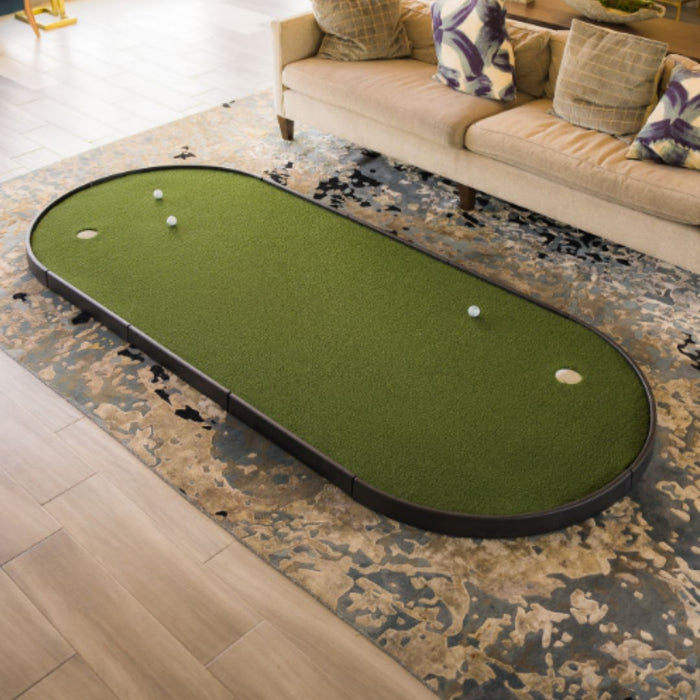 Mini golf putting green mat on a patterned rug in a living room.