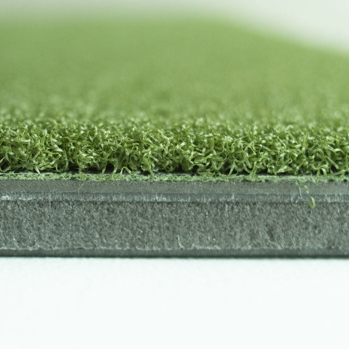 Close-up of green artificial grass with a white background