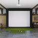 Indoor golf simulator setup with green mat and projector screen.